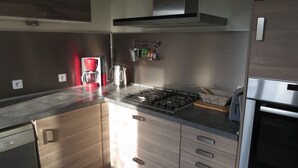 Eine moderne Küche mit Gasherd, Kaffeemaschine und Wasserkocher.