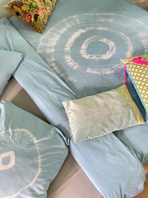 A bed with multiple pillows, some with floral patterns and others plain.