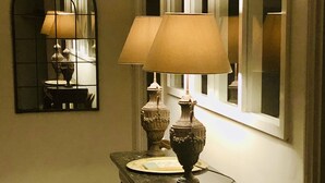 A dimly lit dining area with a table, chairs, and two lamps. A mirror reflects part of the room. - Charming 17th century residence, Calm, Livradois Forez Natural Park, Olliergues (Olliergues)