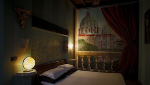 A bedroom with a bed, a nightstand with a lamp, a wall-mounted shelf, and a window with a view of a building. - Charming apartment in the historic center (Roma)