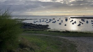 Een kustlandschap met boten afgemeerd bij een rotsachtige kust.