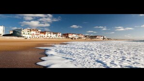 Une plage avec des bâtiments en arrière-plan.