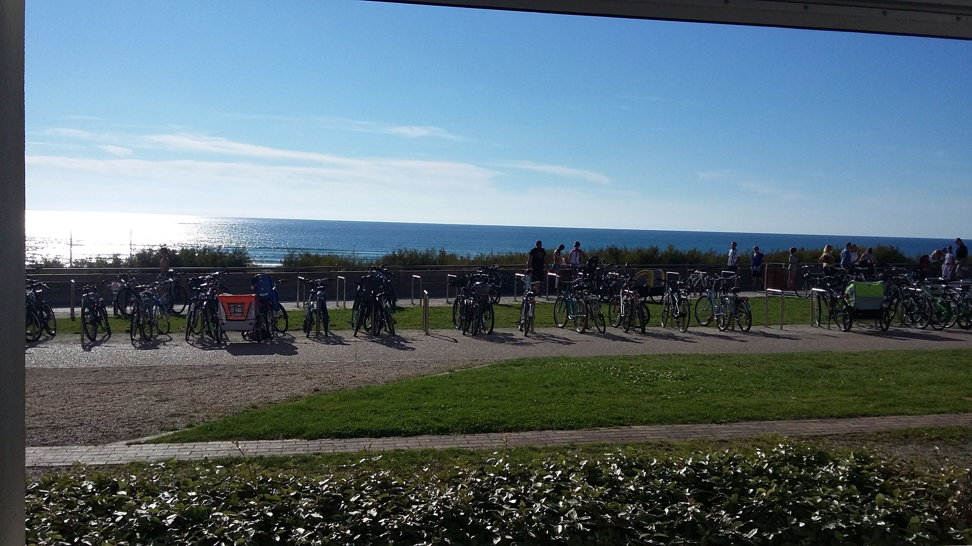 A coastal area with bicycles parked along a path, overlooking the sea.