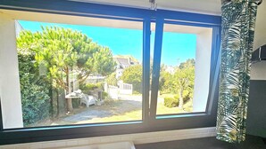 A bathroom with a bathtub, a window with a view of a garden and a white fence. - Charming new house with garden to the South of Wimereux and close to t (Wimereux)