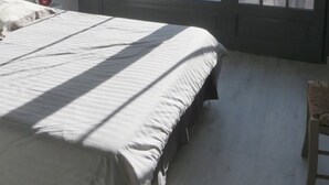 A bedroom with a large sliding glass door leading to a balcony. - Charming house close to the sea and cycle paths (Saint-Martin-de-Ré)