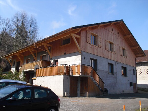 Un bâtiment en bois à deux étages, doté d’un balcon et d’un escalier menant à l’étage supérieur.