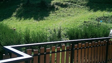 A view of a grassy area with a wooden fence in the foreground.