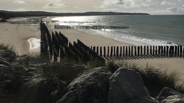 A beach with a wooden jetty, rocky foreground, and a distant shoreline. - Charmante maison au coeur du village /Charming house in the heart of the village (Wissant)