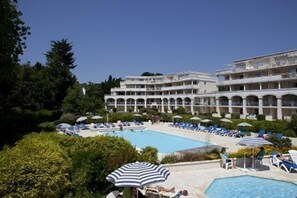 Un hôtel doté d’une piscine, de chaises longues et de parasols.