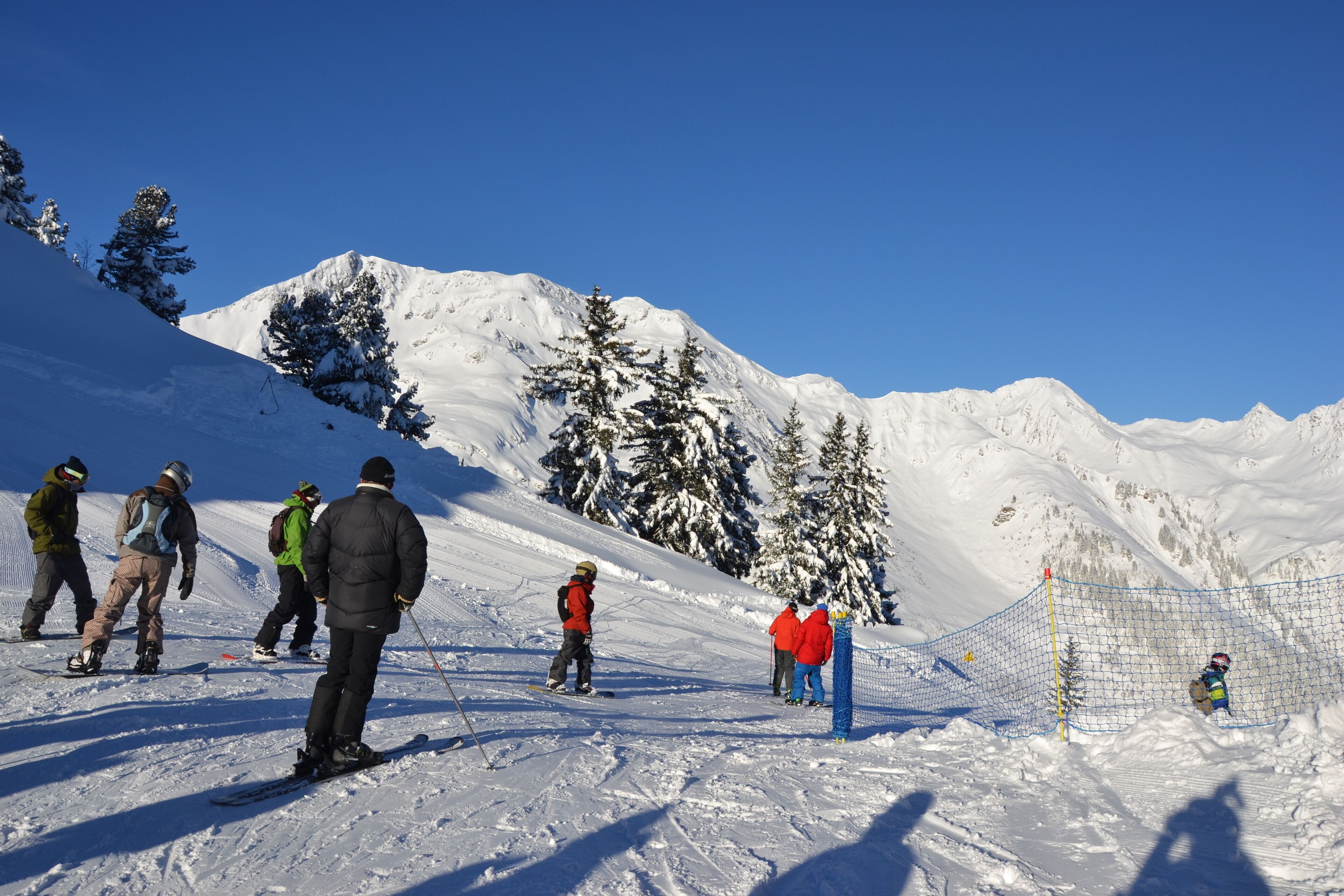 A snowy mountain slope with skiers and snowboarders.