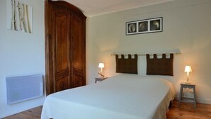 A bedroom with a large bed, wooden wardrobe, two bedside tables with lamps, and a framed picture on the wall. - House, The sea field Plouha (Plouha)