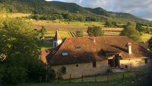 A rural landscape with a stone building, a church, and terraced fields.