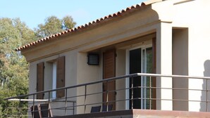 Un bâtiment doté d’un balcon, d’une fenêtre et d’une porte.