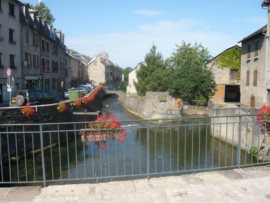 Ein schmaler Wasserweg, gesäumt von Steinbauten, mit einer darüber verlaufenden Brücke.