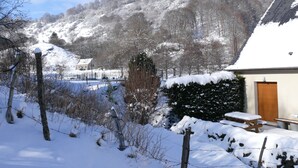 Schneebedeckte Landschaft mit einer Holzhütte, einer Bank und einem Picknicktisch.