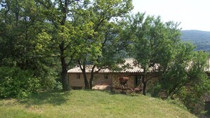A stone building with a tiled roof, surrounded by trees and grass. - Brand new gite in an authentic Provencal Mas, in south Ventoux (Méthamis)
