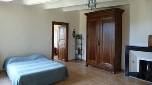 Un dormitorio con cama, armario y chimenea.