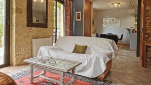A cozy bedroom with a large bed, a small table, and a window with curtains. - Authentic Périgourdine house comfort & calm (Beynac-Et-Cazenac)