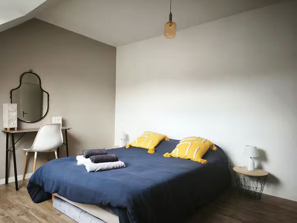 Quarto com cama, escrivaninha, cadeira e abajur.