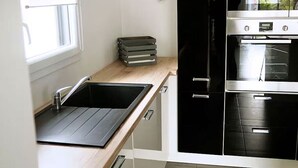 A kitchen with a sink, cabinets, and a stove.