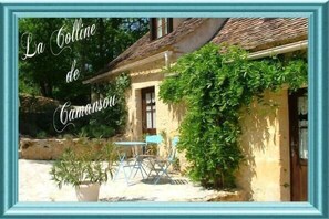 La Colline de Camon offers a charming, rustic retreat with a traditional facade and lush green surroundings.