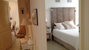 Ein Schlafzimmer mit Bett, Nachttisch, Lampe und Kommode.