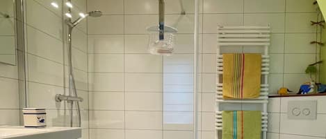 A bathroom with a shower, toilet, and sink.