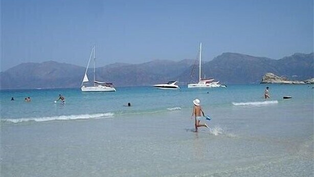 A beach with clear water, boats, and mountains in the background. - Authentic village house: charm, tranquility, and nature, just 15 minutes from Saint-Florent (Saint-Florent)