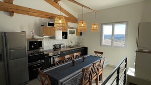 Una cucina moderna con travi in legno, elettrodomestici in acciaio inossidabile e una grande isola con posti a sedere.