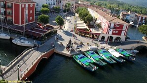 A riverside town with a bridge, boats docked, and buildings along the water. - Country cottage fully furnished, in private property, quiet. (Draguignan)