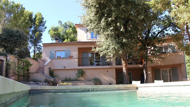 Un edificio de dos pisos con piscina delantera.