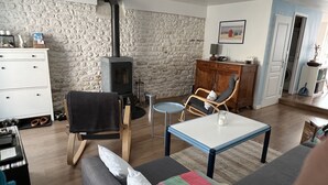 Een gezellige woonkamer met een stenen muur, een open haard, een houten kast, een bank en een salontafel.