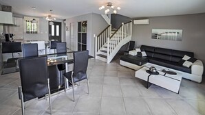 Un espacio moderno de estar con comedor, sofá y escalera.