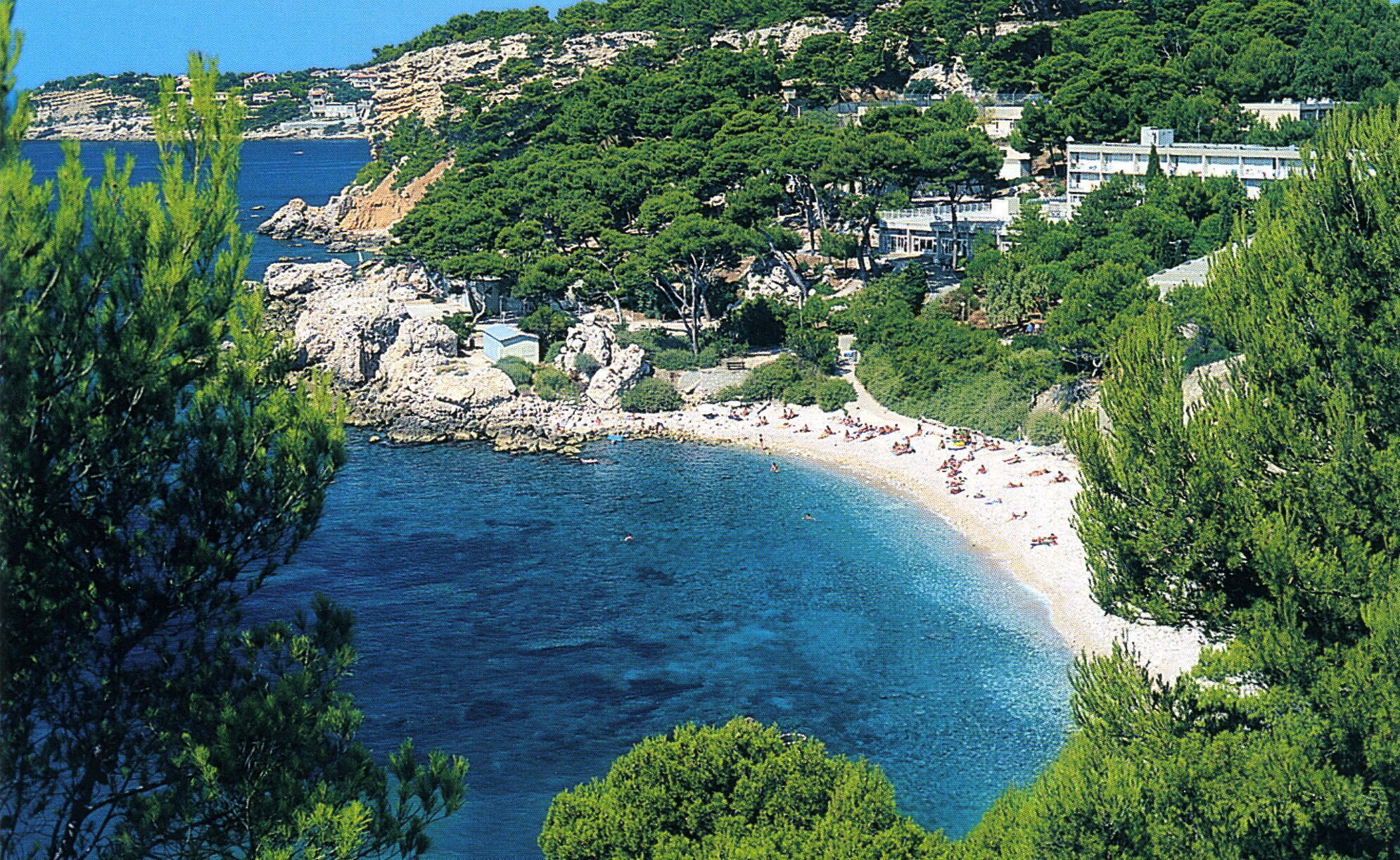 A coastal area with a beach, rocky terrain, and buildings.