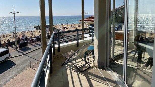 Een balkon met uitzicht op een strand en de oceaan.