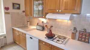 Una cocina con armarios de madera, lavavajillas, estufa y tostadora.