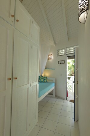 A room with a bed, a wardrobe, a door, and a ceiling with a light fixture.