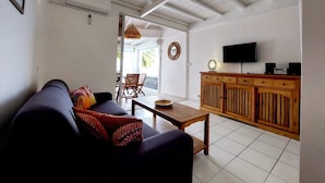 A living room with a sofa, a wooden coffee table, and a TV on a wooden cabinet.