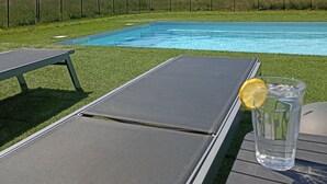 Ein Schwimmbecken mit Blick auf eine ländliche Landschaft, einschließlich Hügeln und einem Dorf.