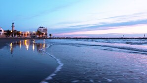 A beach with a calm sea, a pier with buildings, and a lighthouse in the background. - Superb apartment ideally located in the city center with Clim (6 pers, 80m² ) (Nîmes)
