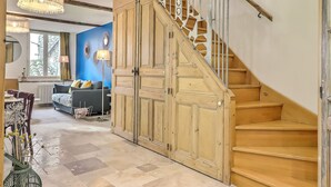 A staircase with wooden steps and a metal railing, leading to a landing with a blue wall and decorative mirrors. - Superb apartment ideally located in the city center with Clim (6 pers, 80m² ) (Nîmes)