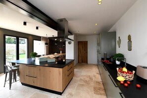 A modern kitchen with a central island, built-in appliances, and a view to the outdoors.