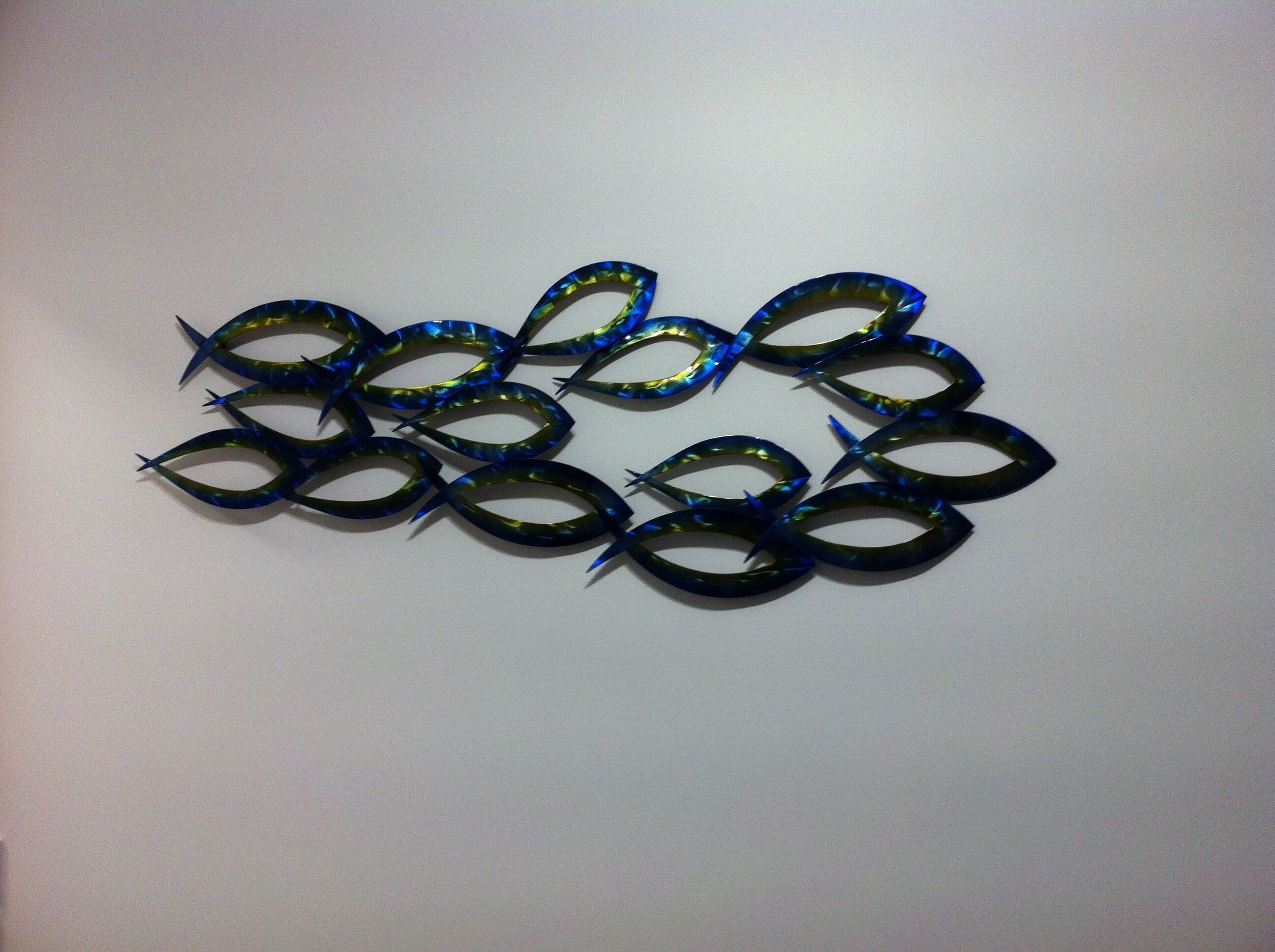 A collection of blue and green decorative items arranged in a pattern on a white surface.