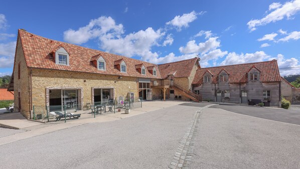 A building with a courtyard, stone walls, and red-tiled roofs. - Gîte with covered swimming pool on the Opal Coast (Tingry)