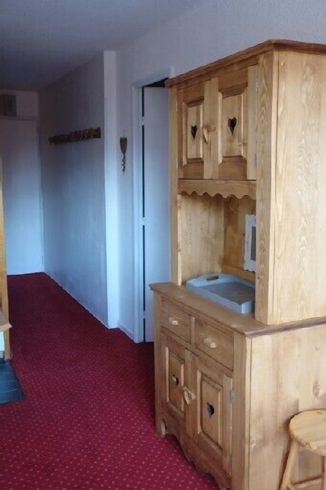 A wooden cabinet with drawers and a small stool.