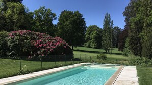 Een rechthoekig zwembad met helderblauw water, omgeven door een betonnen terras.