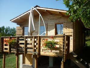 A wooden cabin with a balcony, windows, and flower boxes. - WOODEN CHALET RENTAL IN THE HEART OF NATURE (Neschers)
