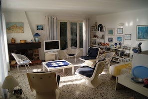 A living room with a fireplace, seating area, and a television. - NEO-PROVENCAL VILLA WITH SECURE INFINITY POOL (Roquebrune-Sur-Argens)