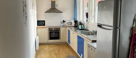 Una cocina compacta con estufa, microondas y refrigerador.