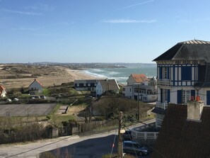 Un pueblo costero con casas, una playa y el mar.